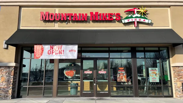 A beige storefront with a bank of windows in the front. The top of the buildings sayd "Mountain Mike's