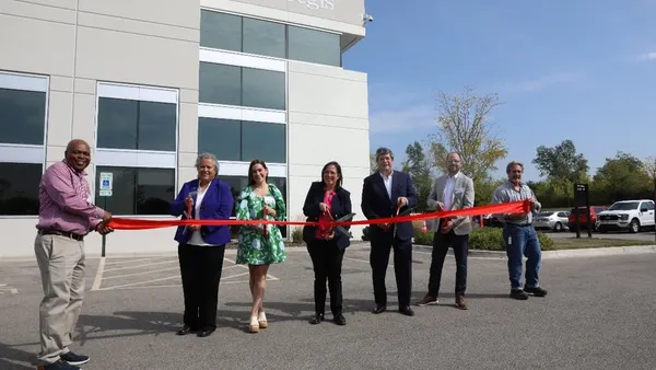 7 people smile and cut a red ribbon in front of Pregis' new facility in Elgin, Illinois, on Sept. 19, 2025.