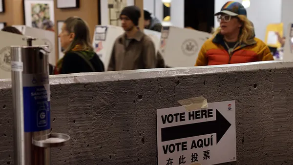 Voters stand near polling machines.