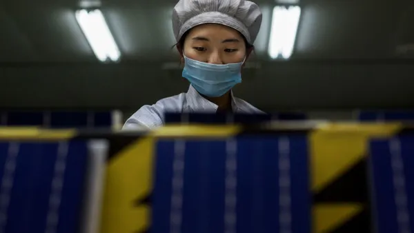 A technician prepares solar cells at a factory.