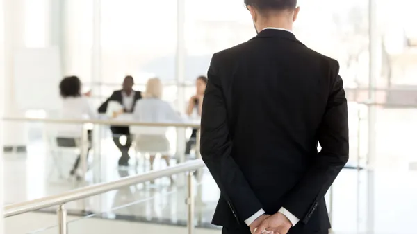 Nervous businessman waiting to enter at business meeting rear view.