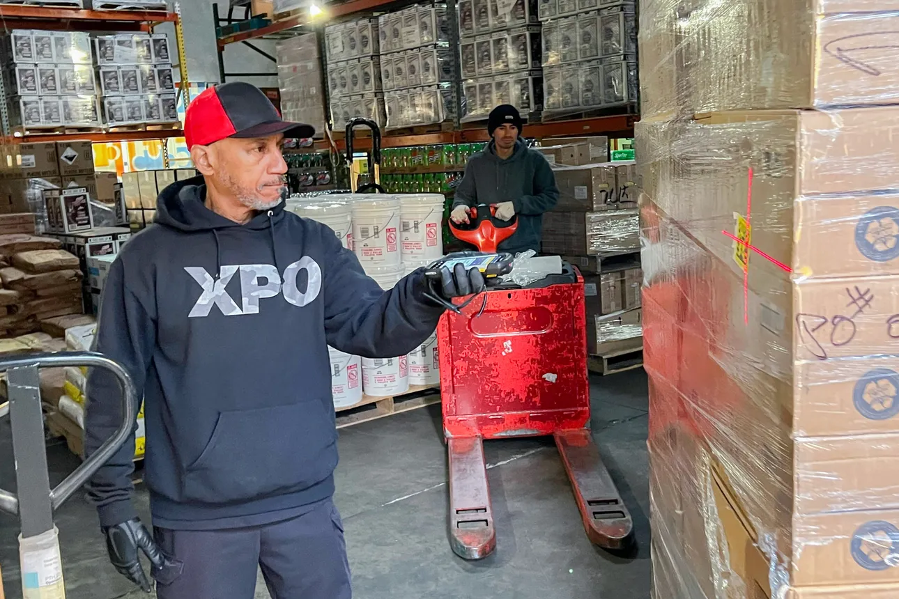 XPO driver Steadman &quot;Steve&quot; Mitchell scans a pallet of cup lids as it comes off his truck at M&amp;K Food.