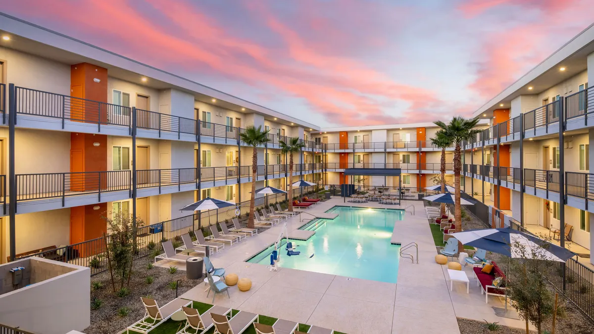 Three story apartments surrounding a pool.