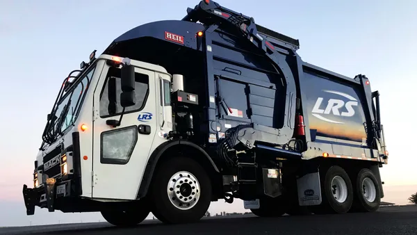 Blue garbage truck on road