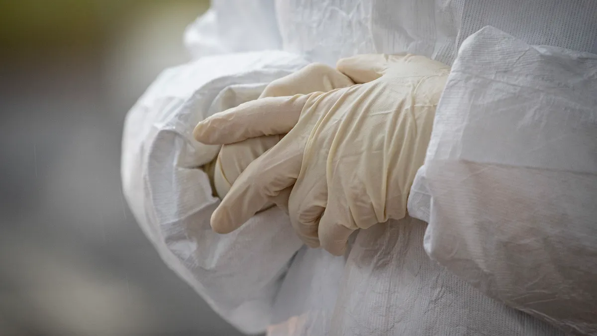 A medical technician adjusts her gloves at a COVID-19 Community-Based Testing Site at the PNC Bank Arts Center in Holmdel, N.J., March 23, 2020. The testing site, established in partnership with the F