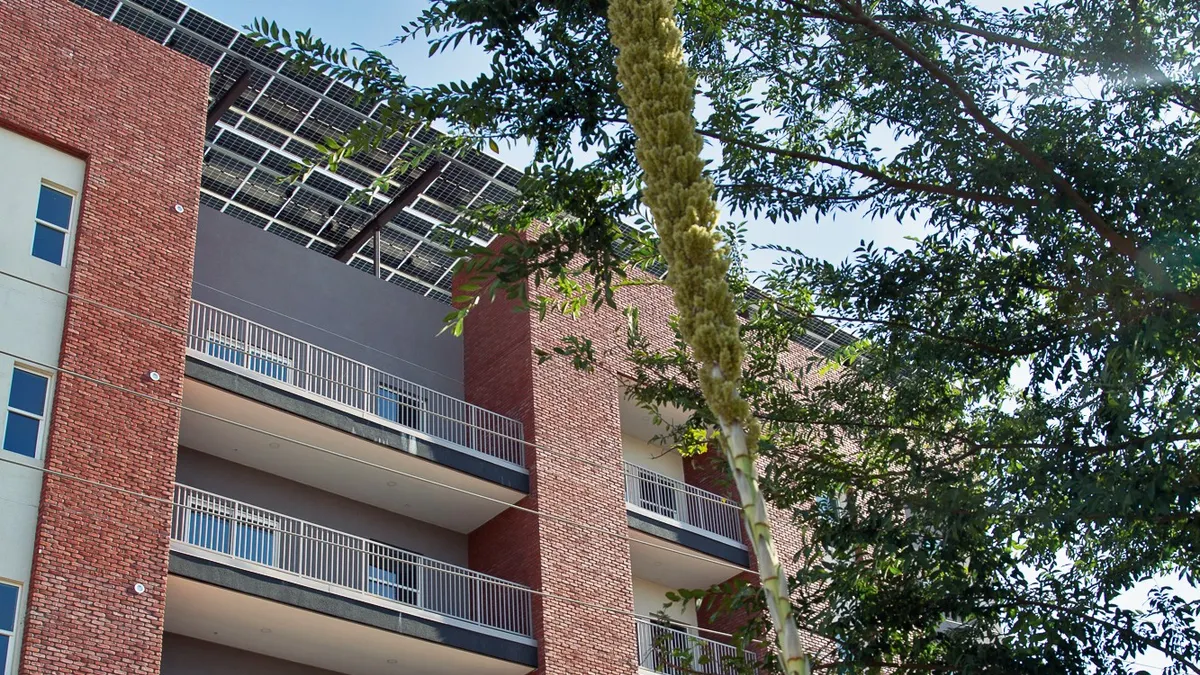 An apartment building with solar panels on the roof.