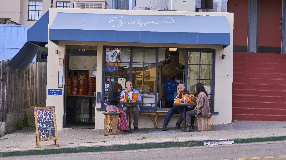 An image of a small restaurant with a blue overhang.