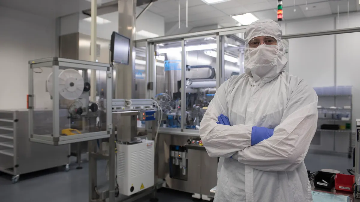 Woker in Pharmaceutical lab with equiment behind