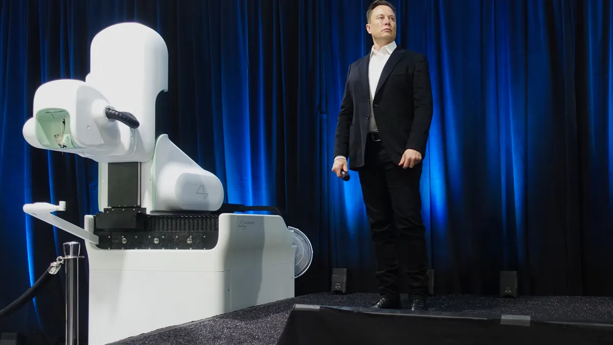 Elon Musk speaks at a Neuralink event with surgical robot in the foreground.