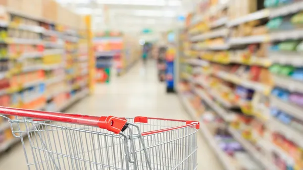 Empty shopping cart in a grocery store aisle