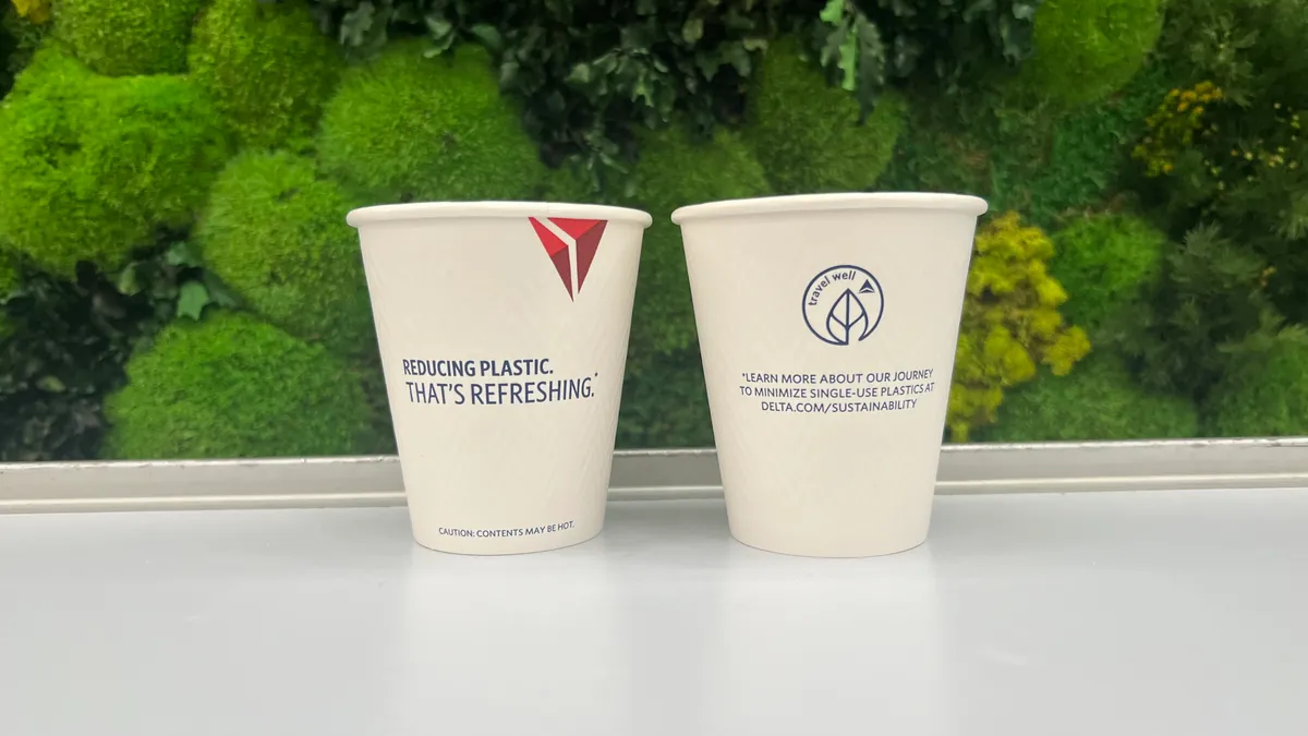 Two paper cups with Delta Air Lines' branded messaging.