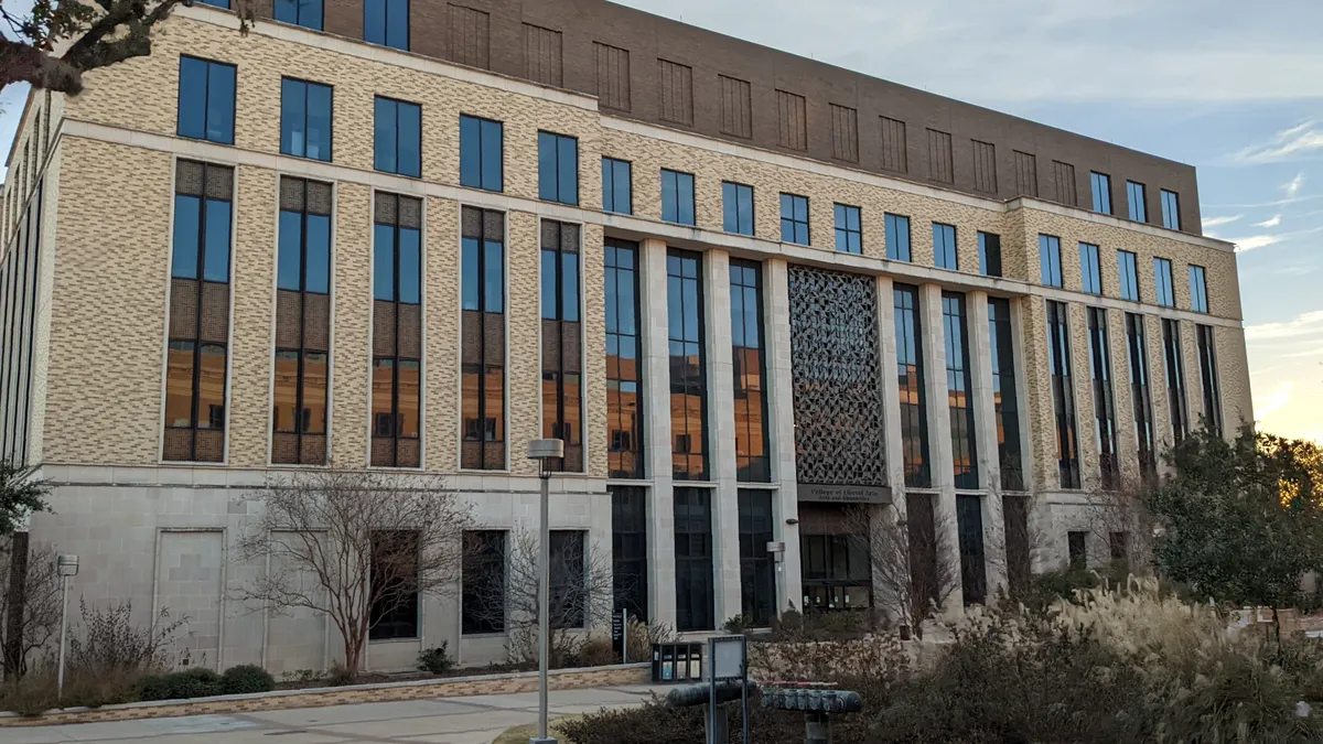 A large squared-off building on a southern college campus