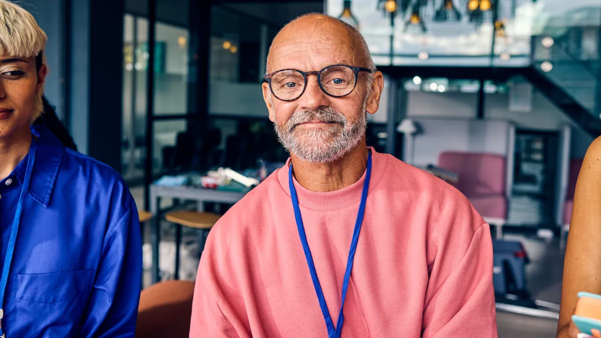 An older white man looks directly into the camera