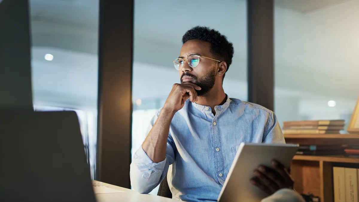 Shot of a young businessman using a digital tablet in an office at night