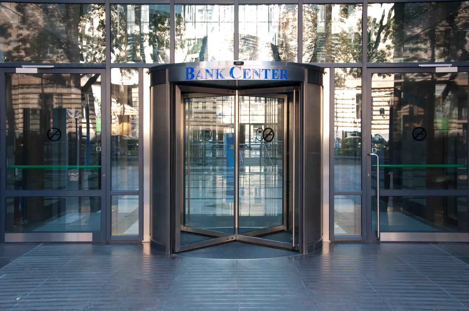 The entrance to a bank center with revolving doors is pictured.