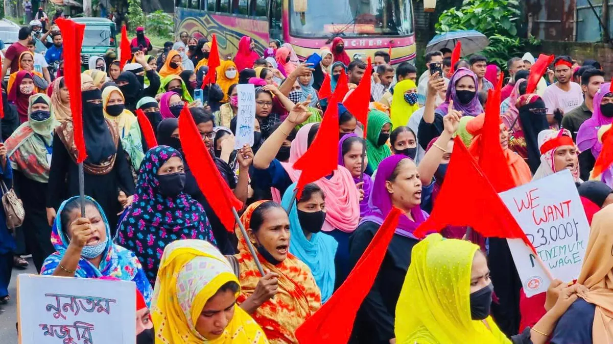 Bangladesh garment workers are seen holding signs in protest for a higher minimum wage.