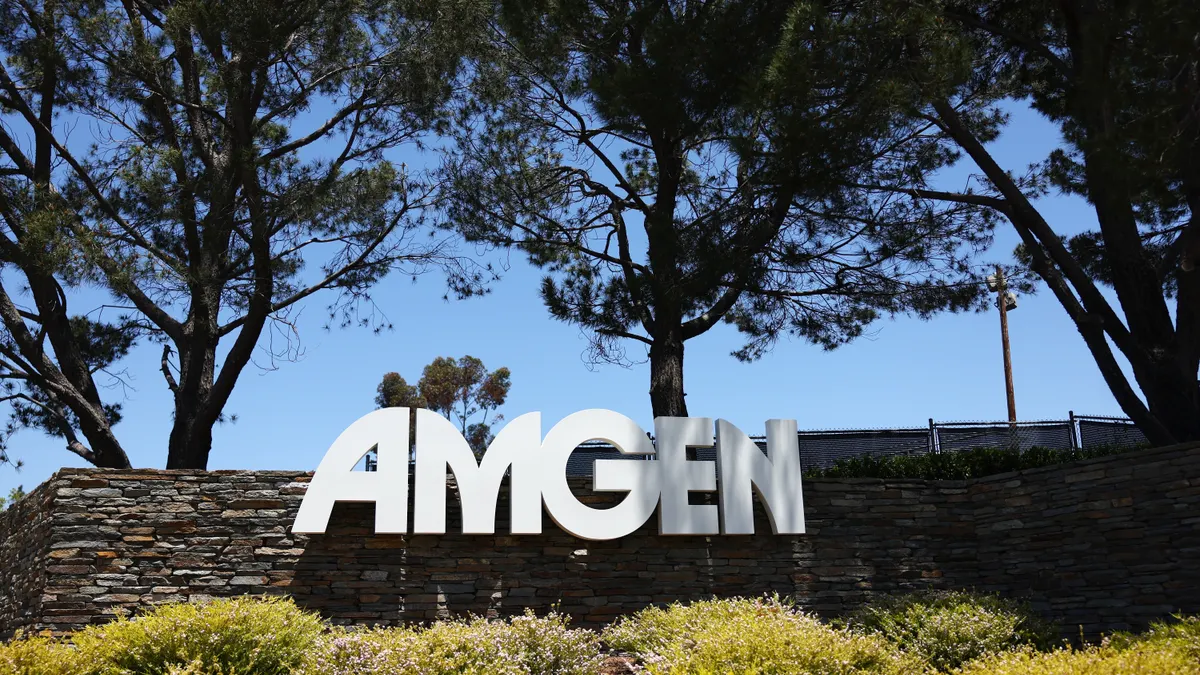 Large letters spelling Amgen are seen next to a stone wall
