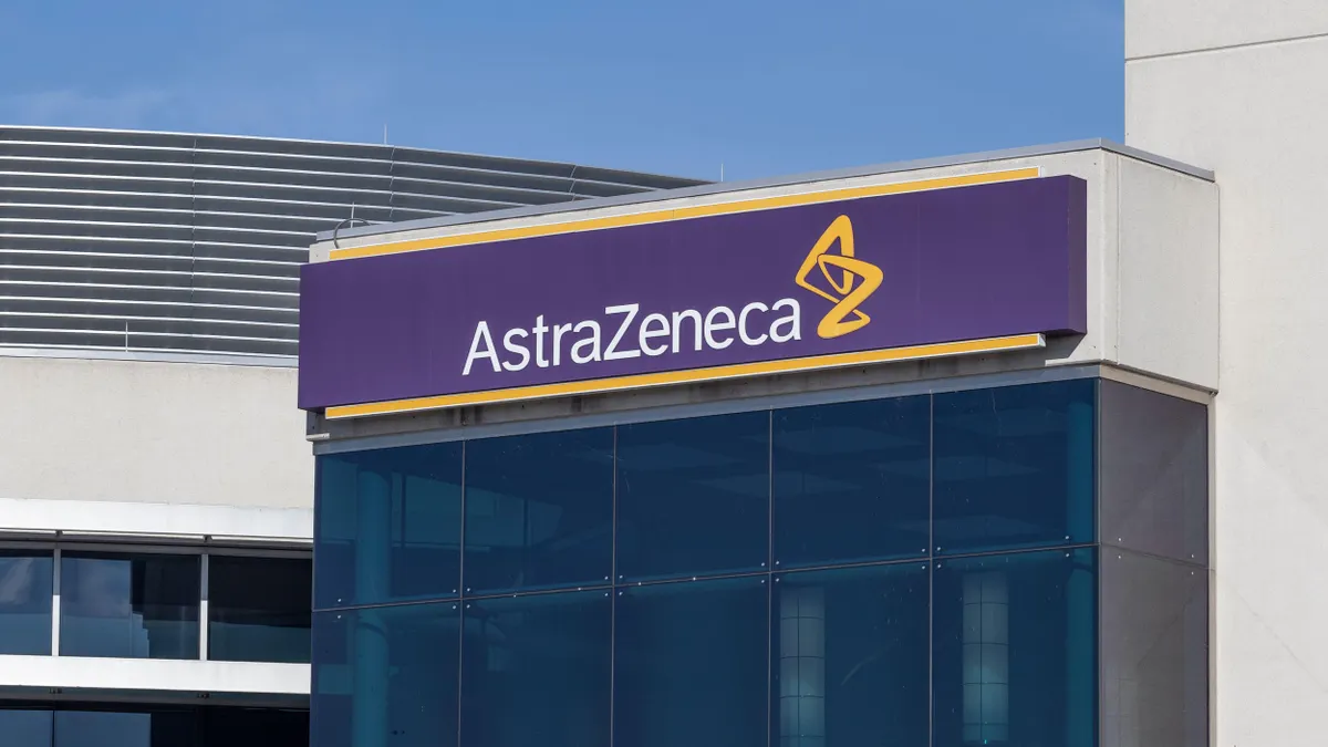 Close-up of a building with a purple and yellow AstraZeneca sign on the exterior.