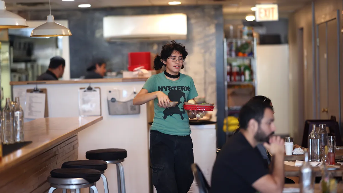 A server waits on customers in a cafe.