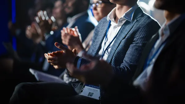 closeup of an event attendee in business attire clapping