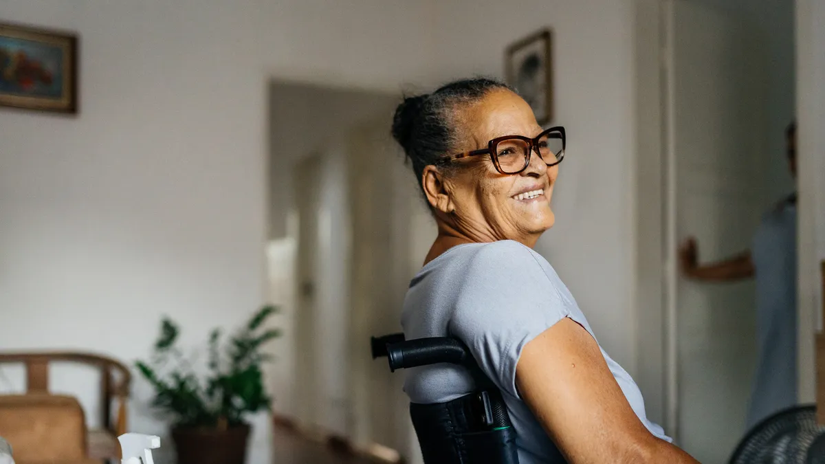 A Black woman smiles in a wheelchair