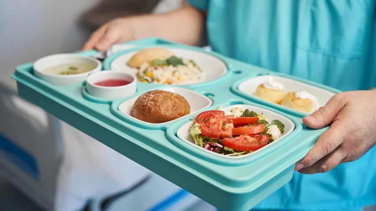 Nurse serving dietary meal