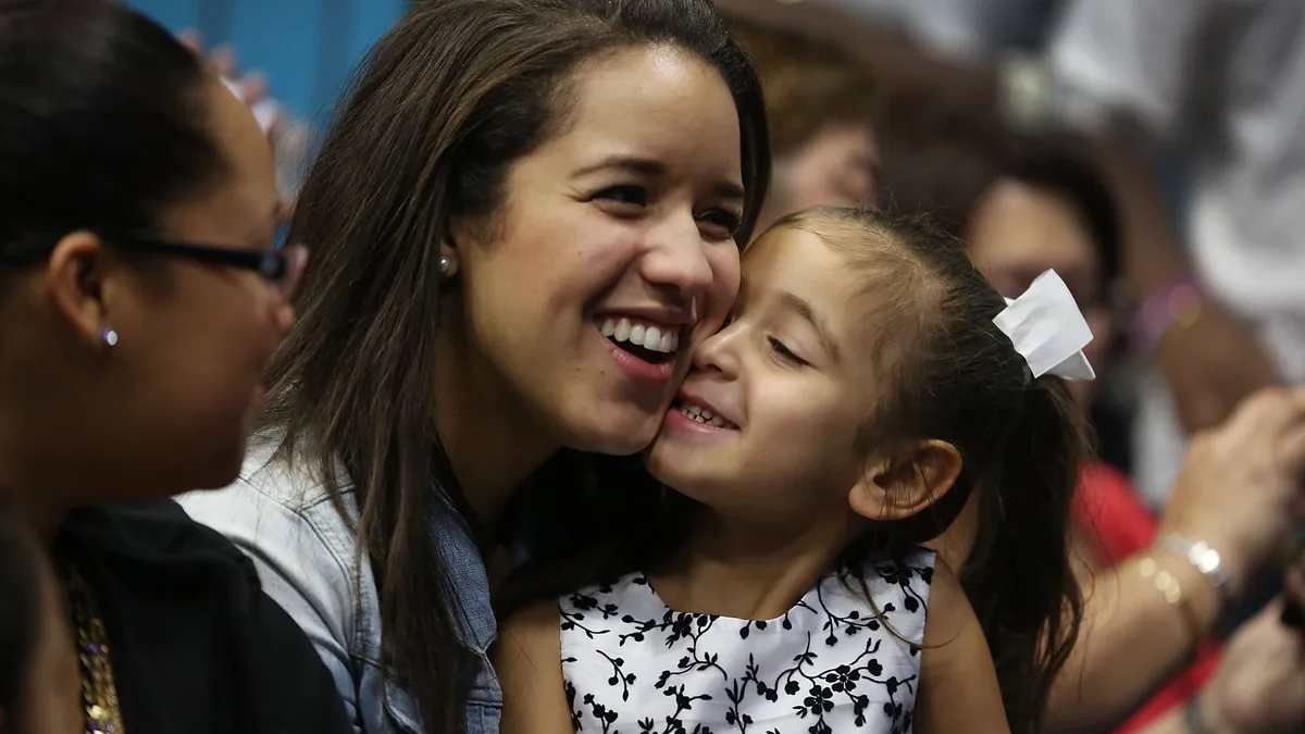 Nathalie Ogando sits with her adopted cousin, Lean Martinez, after she was adopted during a ceremony.