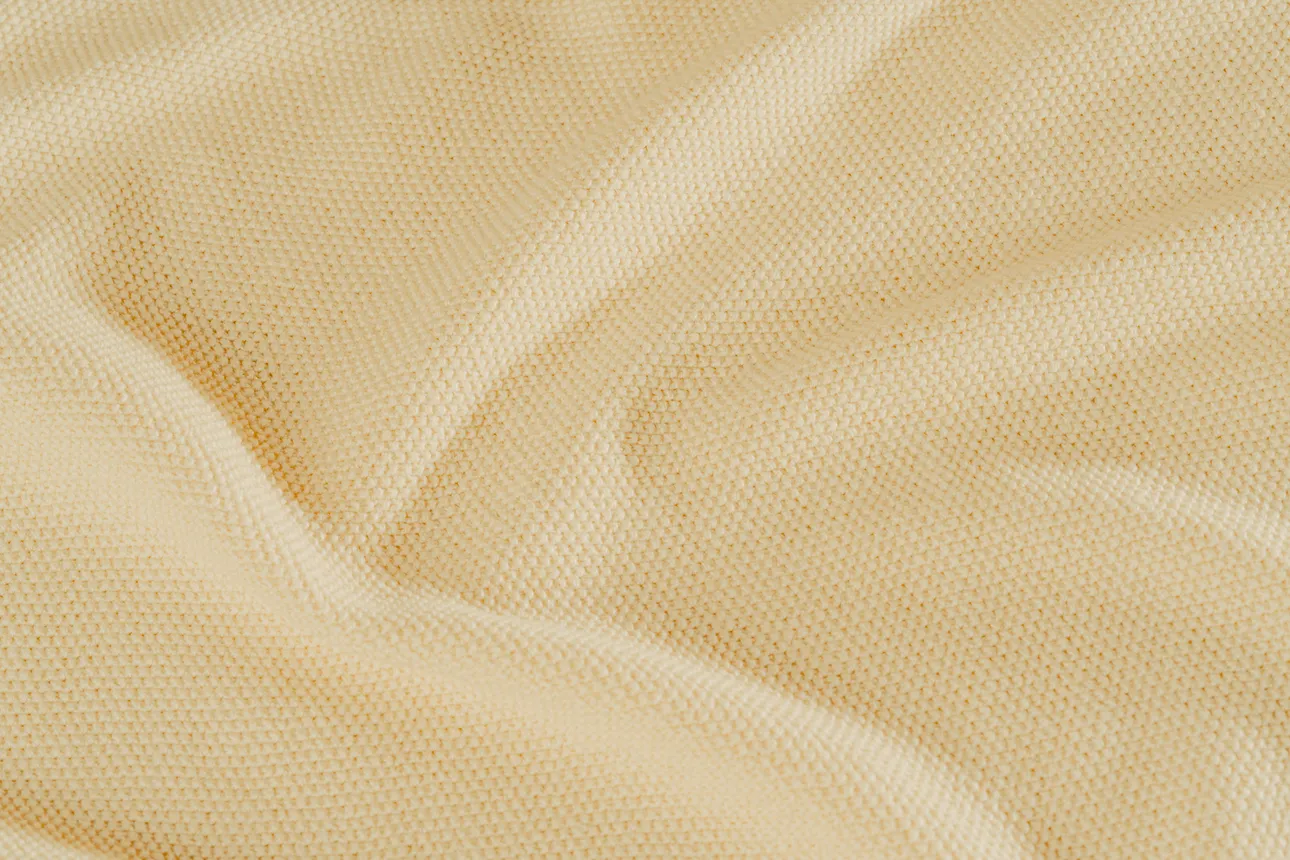 A Kelsun knit sample of tan fabric.