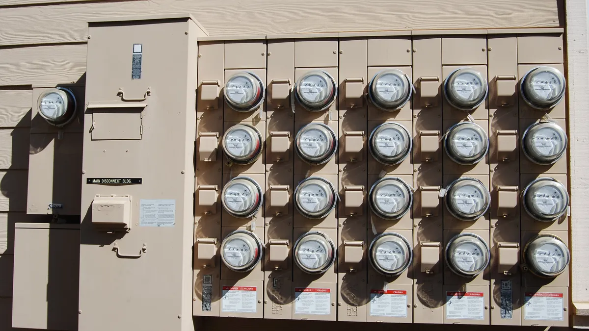 A bank of electricity meters on the side of a building.