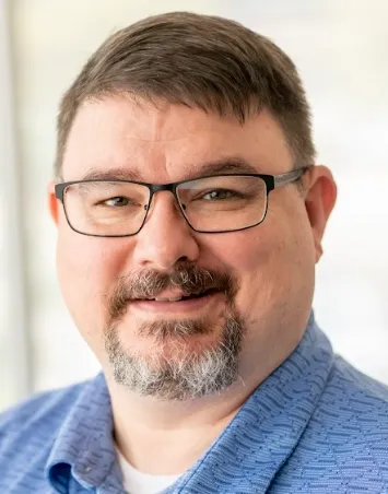 Man with glasses and dark hair.