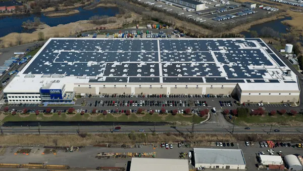 An aerial view of a large building covered in solar panels.