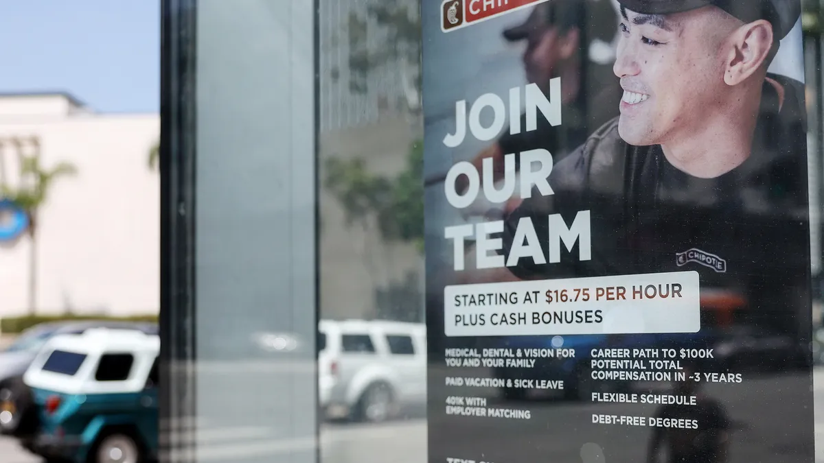 A 'Join Our Team' sign is displayed outside a Chipotle location, advertising a $16.75 wage with an opportunity to earn up to $100,000.