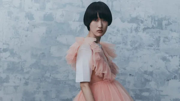 A person in pink tulle stares at the camera