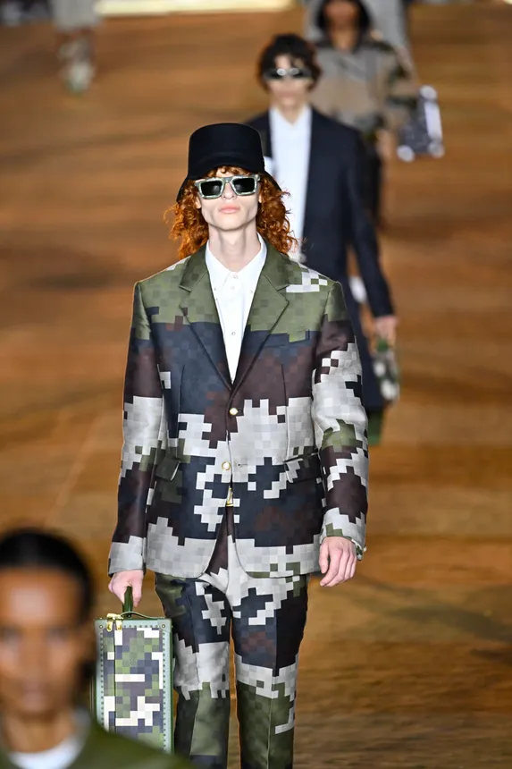 A model walks the runway wearing a pixelated camouflage suit.