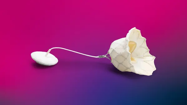 The white Abbott Tendyne mitral valve is shown against a bright pink background.