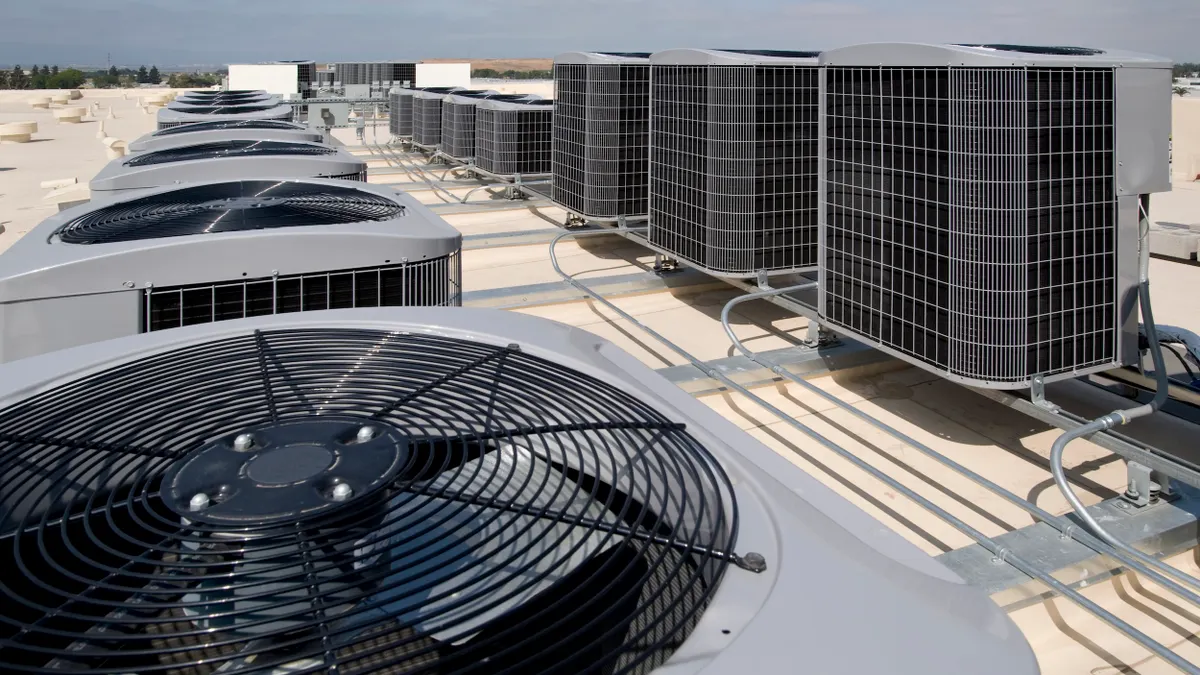 Several industrial air condtioning units on a roof.