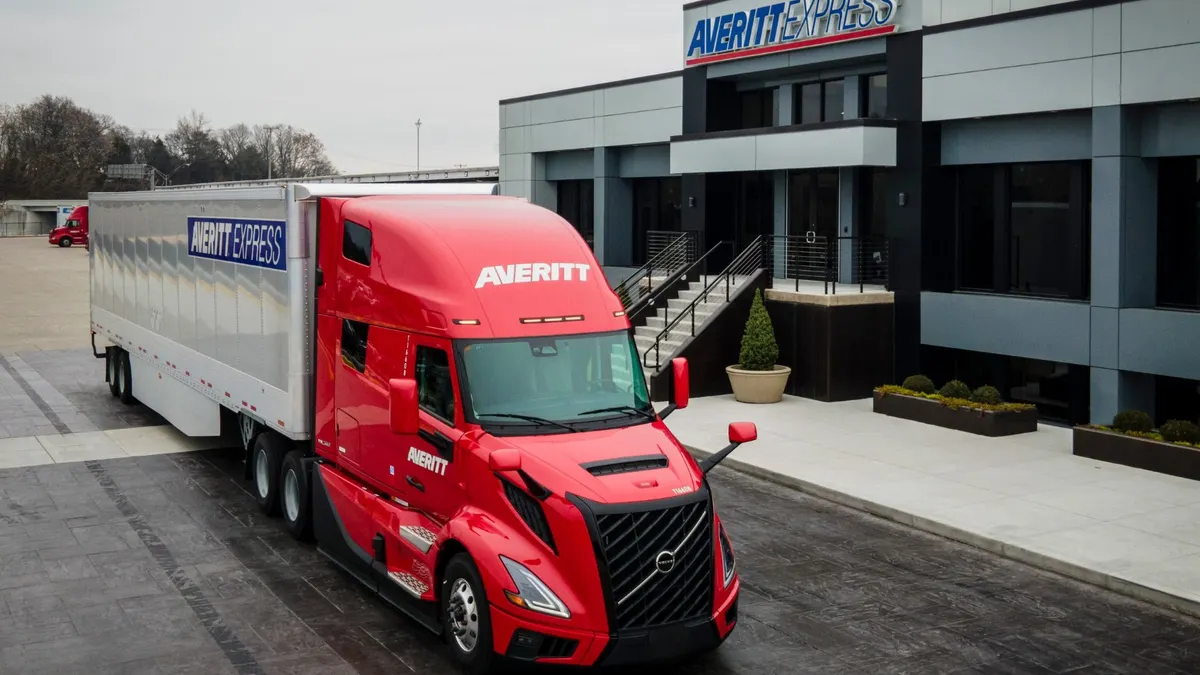 An Averitt Express tractor-trailer outside a building featuring the carrier's name and logo.