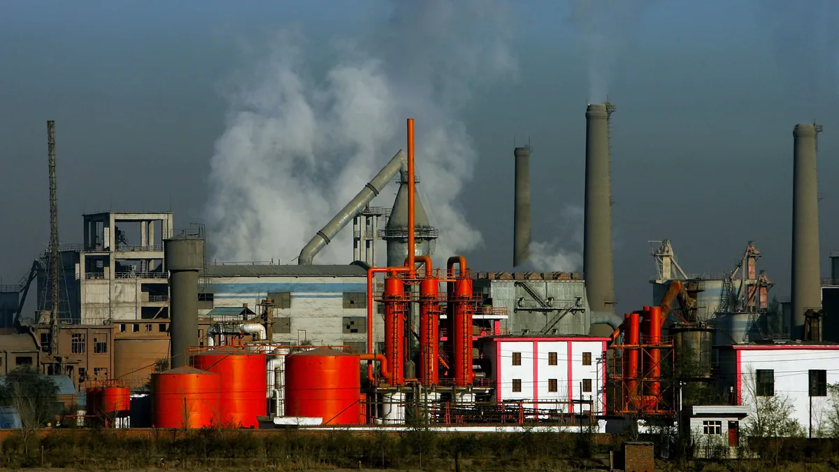 Steam emerges from a facility with multiple smoke stacks.