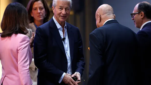 JPMorgan Chase CEO Jamie Dimon stands with a group of four other people.