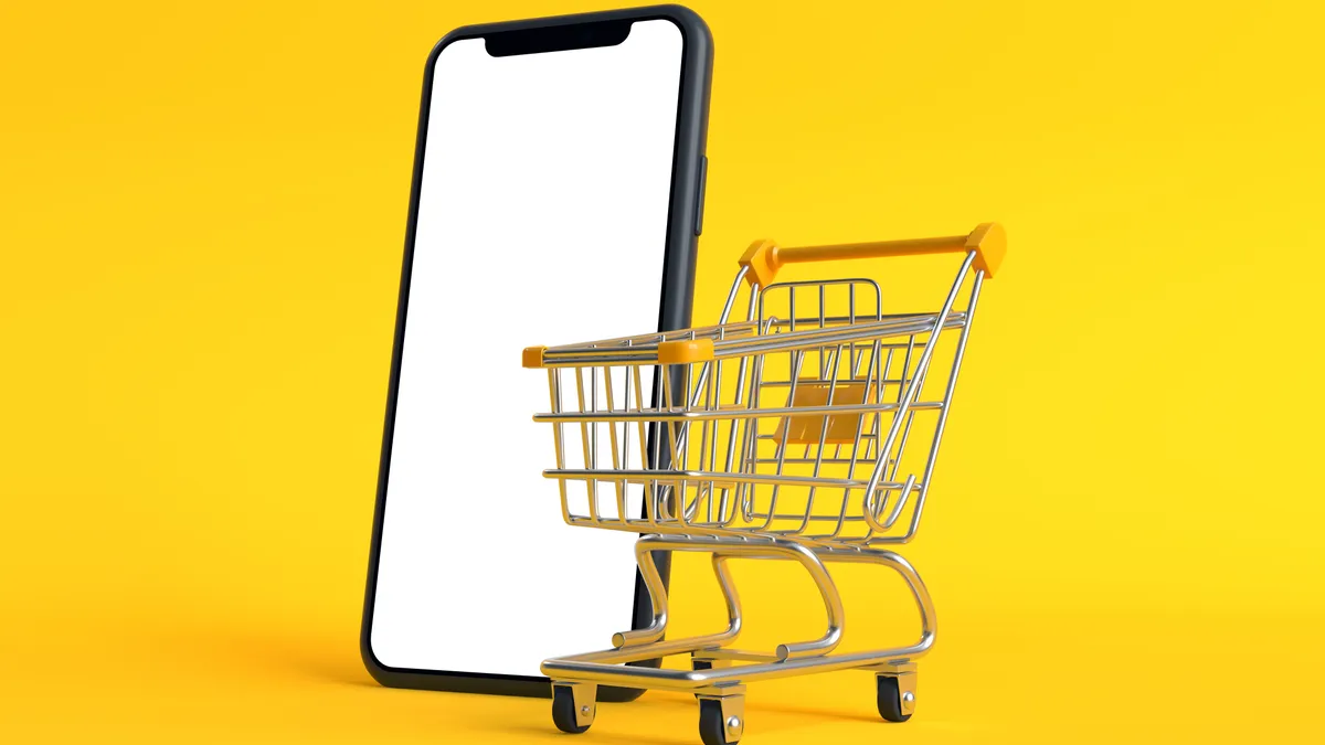 Shopping cart with empty smartphone screen on a yellow background