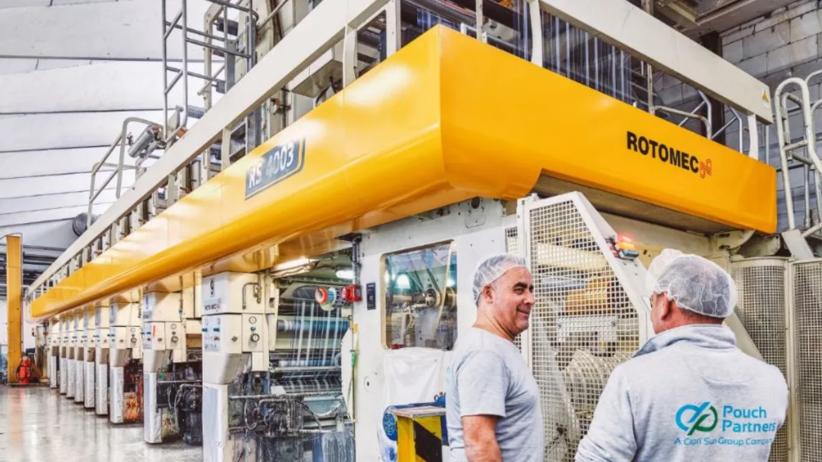 Two people standing in a pouch manufacturing facility