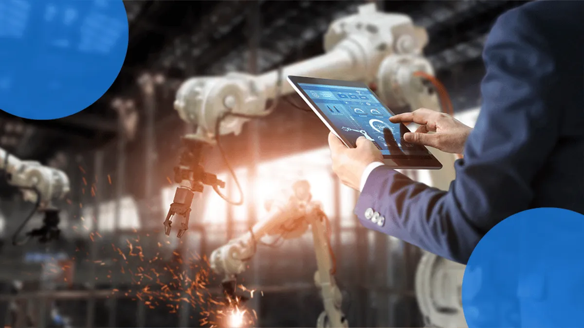 A business professional stands in a modern factory environment, surrounded by robotic arms, while holding a digital tablet