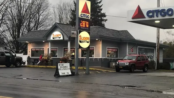 A photo of the exterior of a gas station and convenience store. A sign out front and on the fuel canopy says Citgo while a sign on the store says Sliders Food Mart.