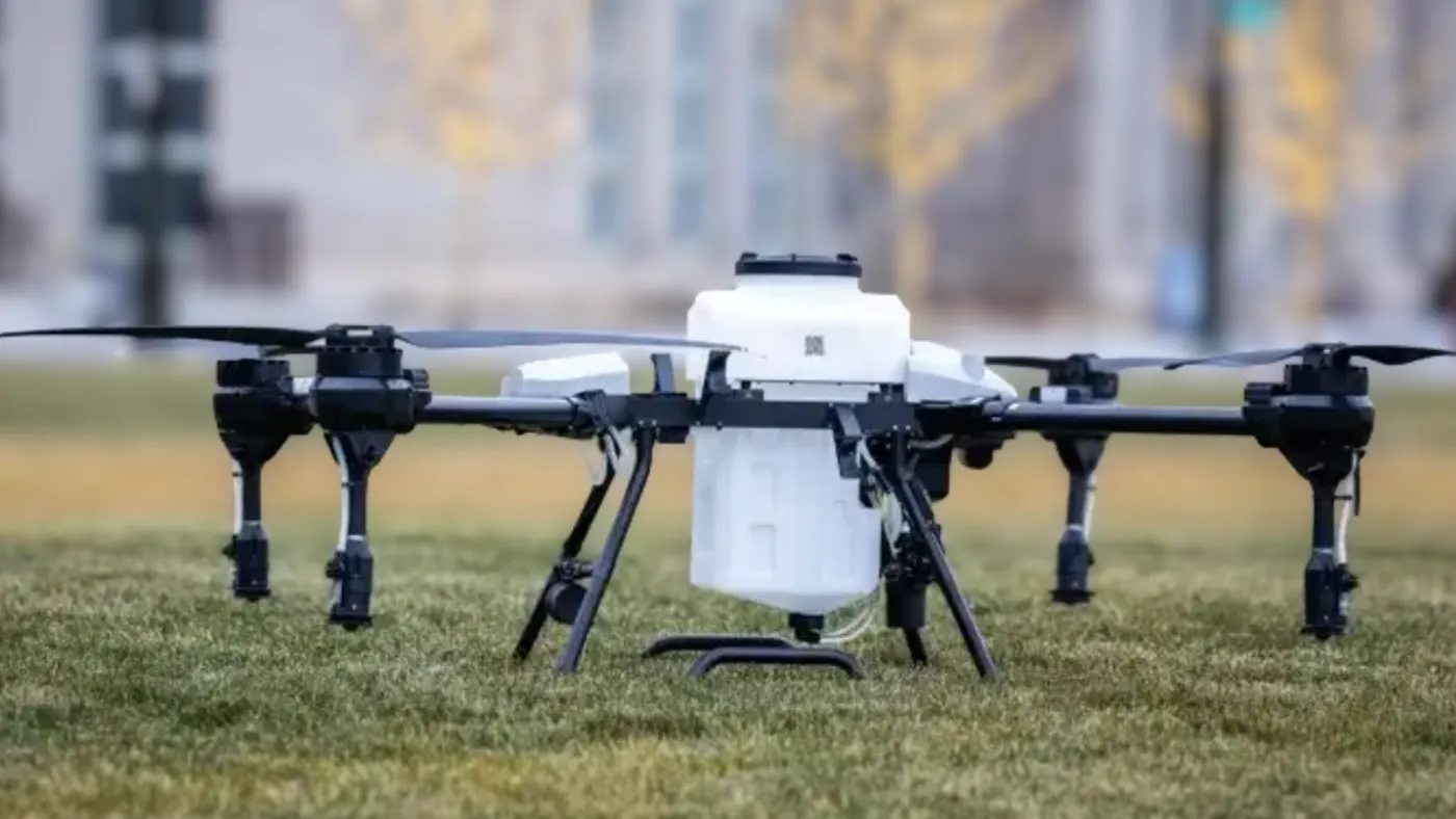 A black and white drone laying on green grass.