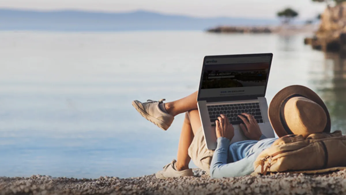 Young woman using laptop on a beach