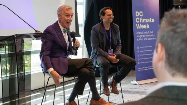 Bill Nye gesturing seated next to Arcadia CEO Kiran Bhatraju with a DC Climate Week sign in the far right of the image.