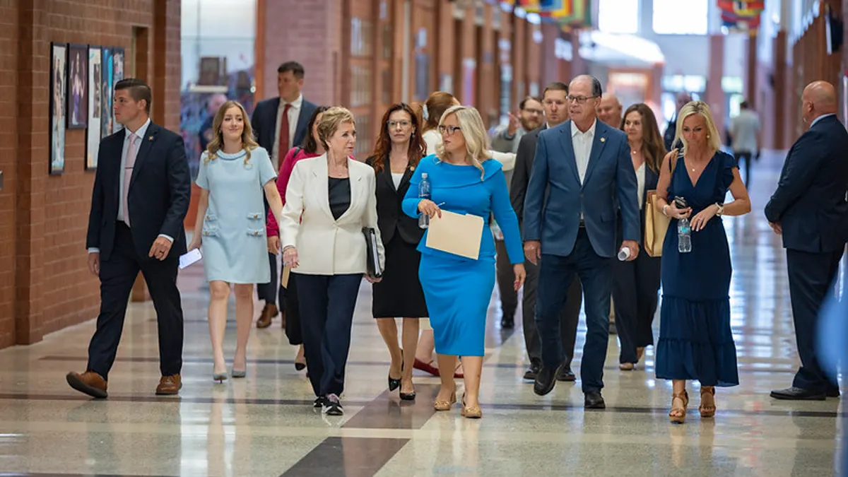A group of people are walking down a hallway in a school.