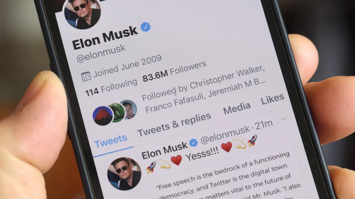 A photo of a cell phone showing Elon Musk's Twitter profile.