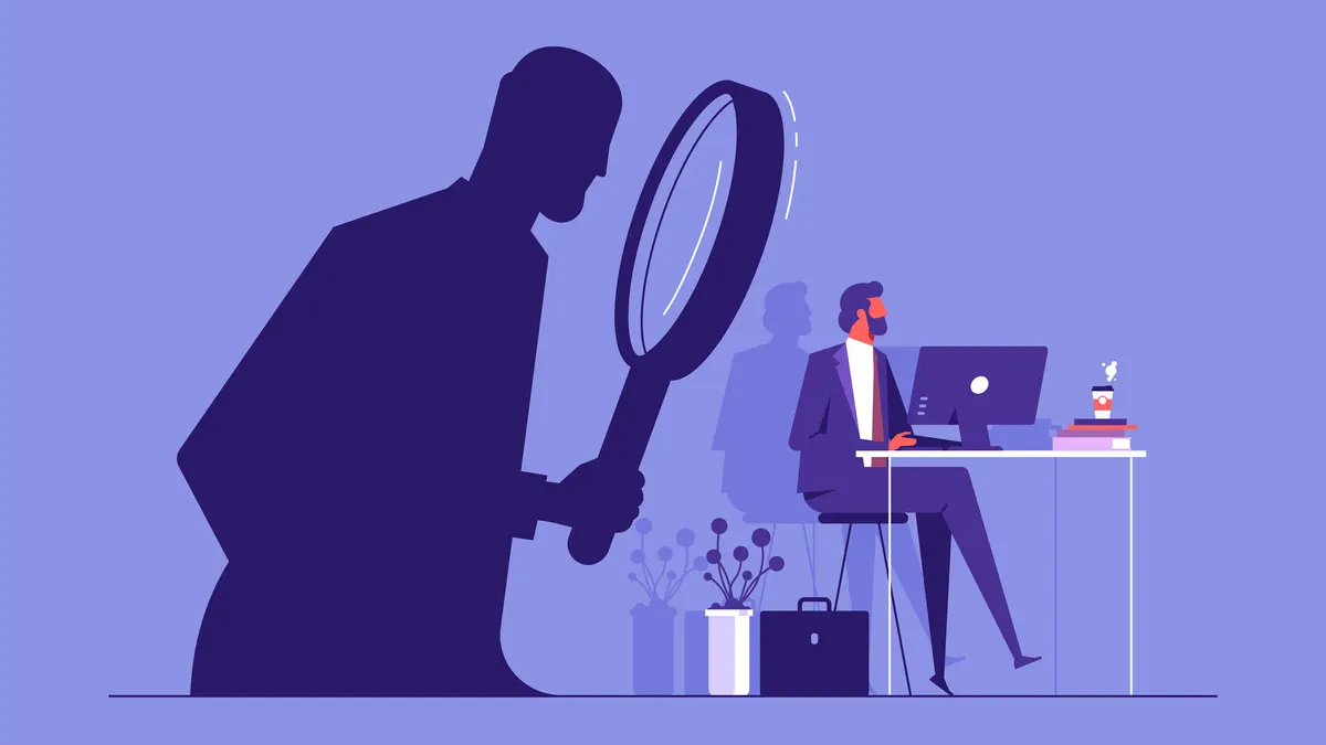 Employee work is monitored or online stalkingÂ concept, person sitting on a computer in his office while a stalker is watching him from the shadow without being noticed