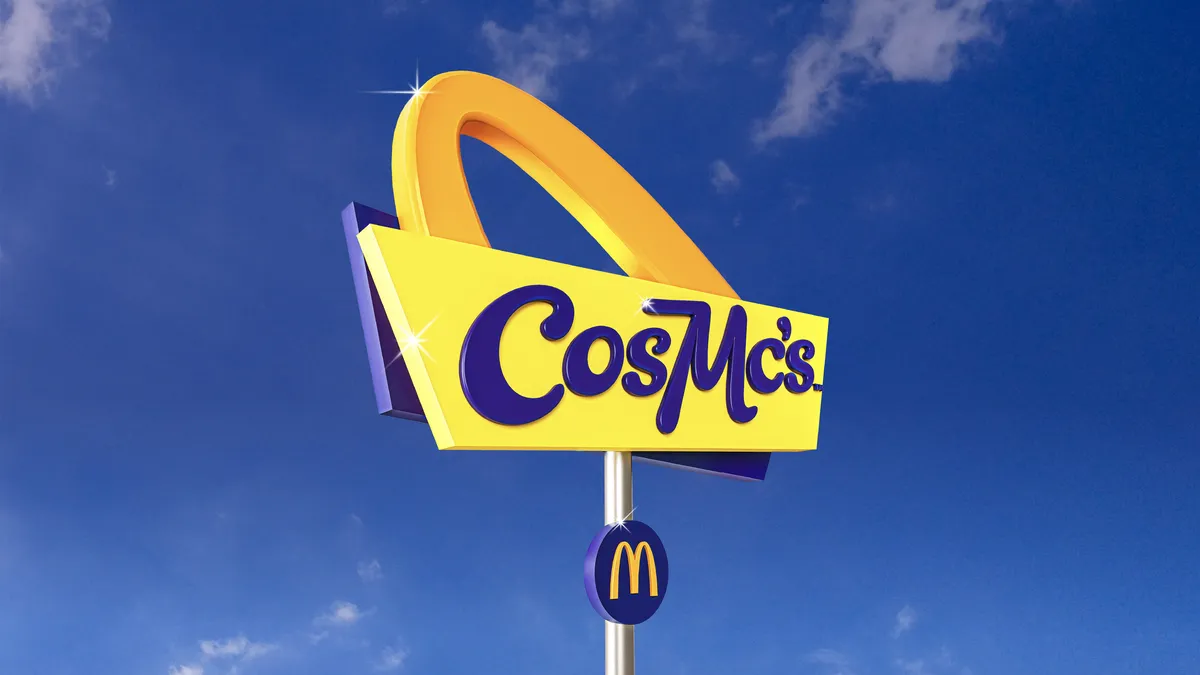 A sign for McDonald's new CosMc restaurant concept is in the foreground, with blue sky in the background